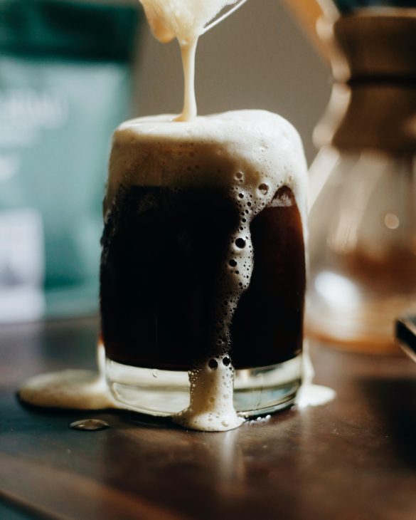 clear drinking glass with stout beer made with lactose brewing